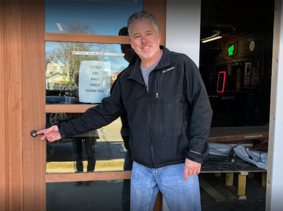 guy standing on door showing a lock lock hole